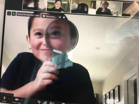 Student over a zoom call with magnifying glass
